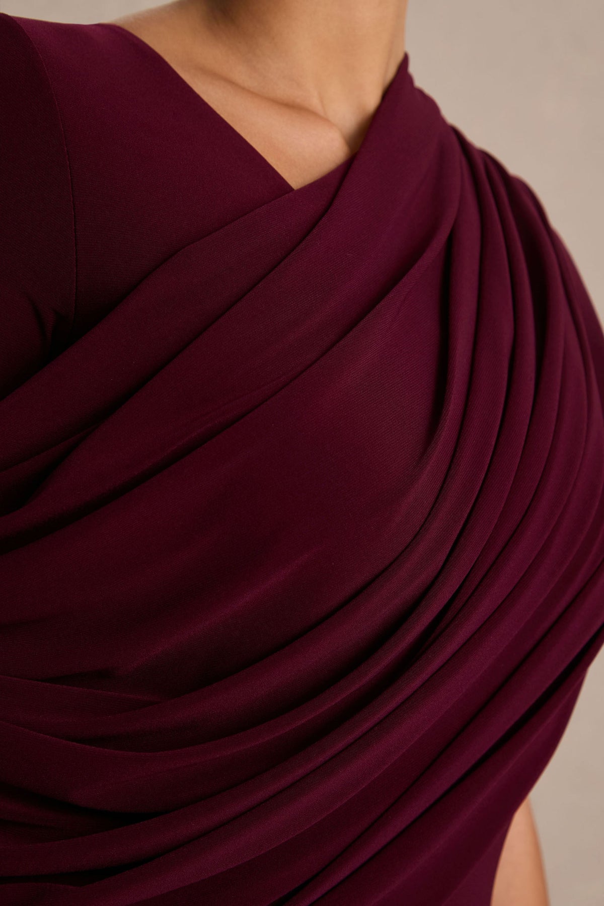 Rubelle | Burgundy långklänning med asymmetrisk halsringning och draperade detaljer