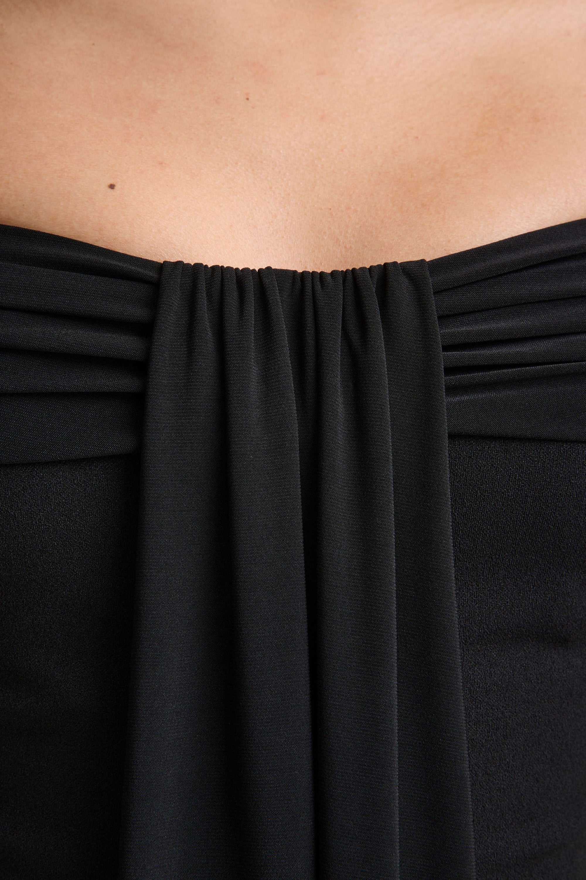Kalida | Svart byxdress med bardothalsringning och draperade detaljer