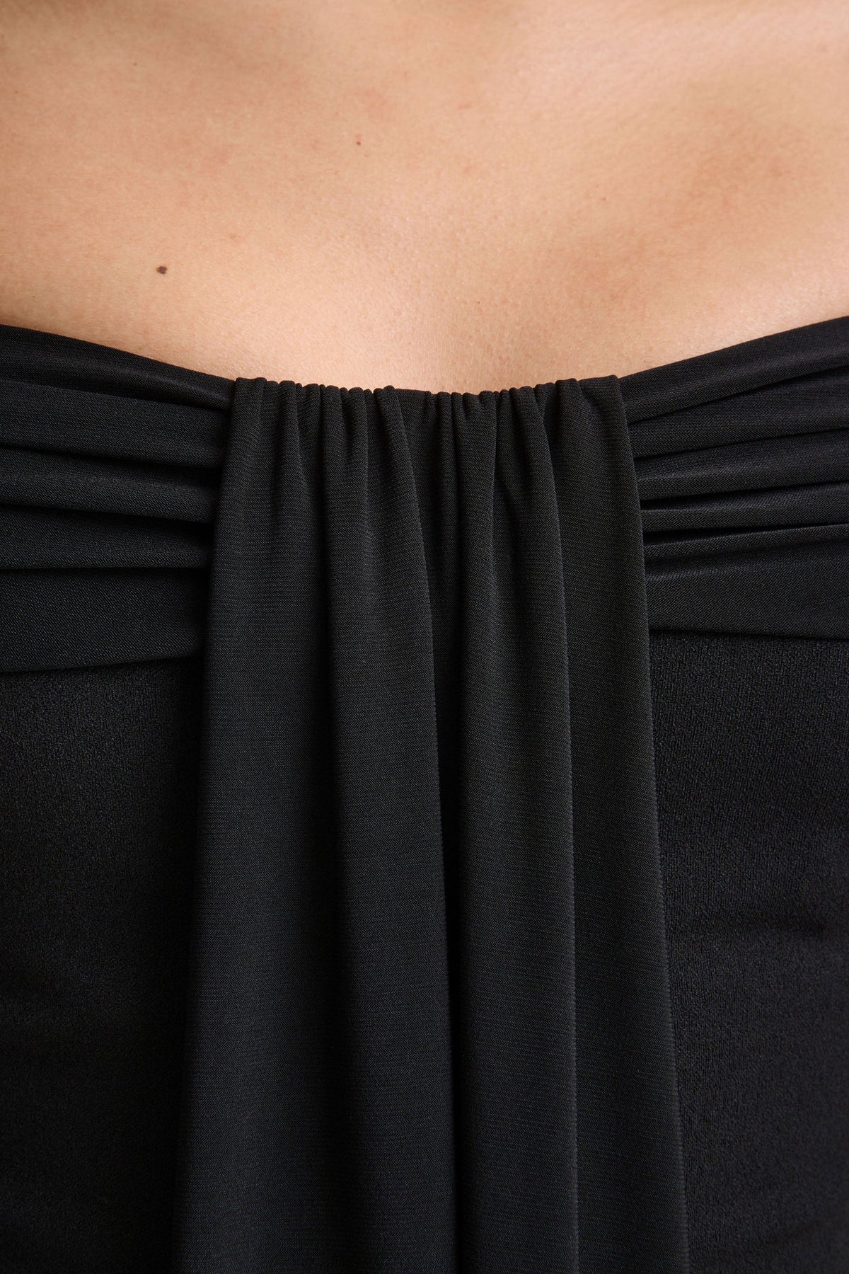 Kalida | Svart byxdress med bardothalsringning och draperade detaljer