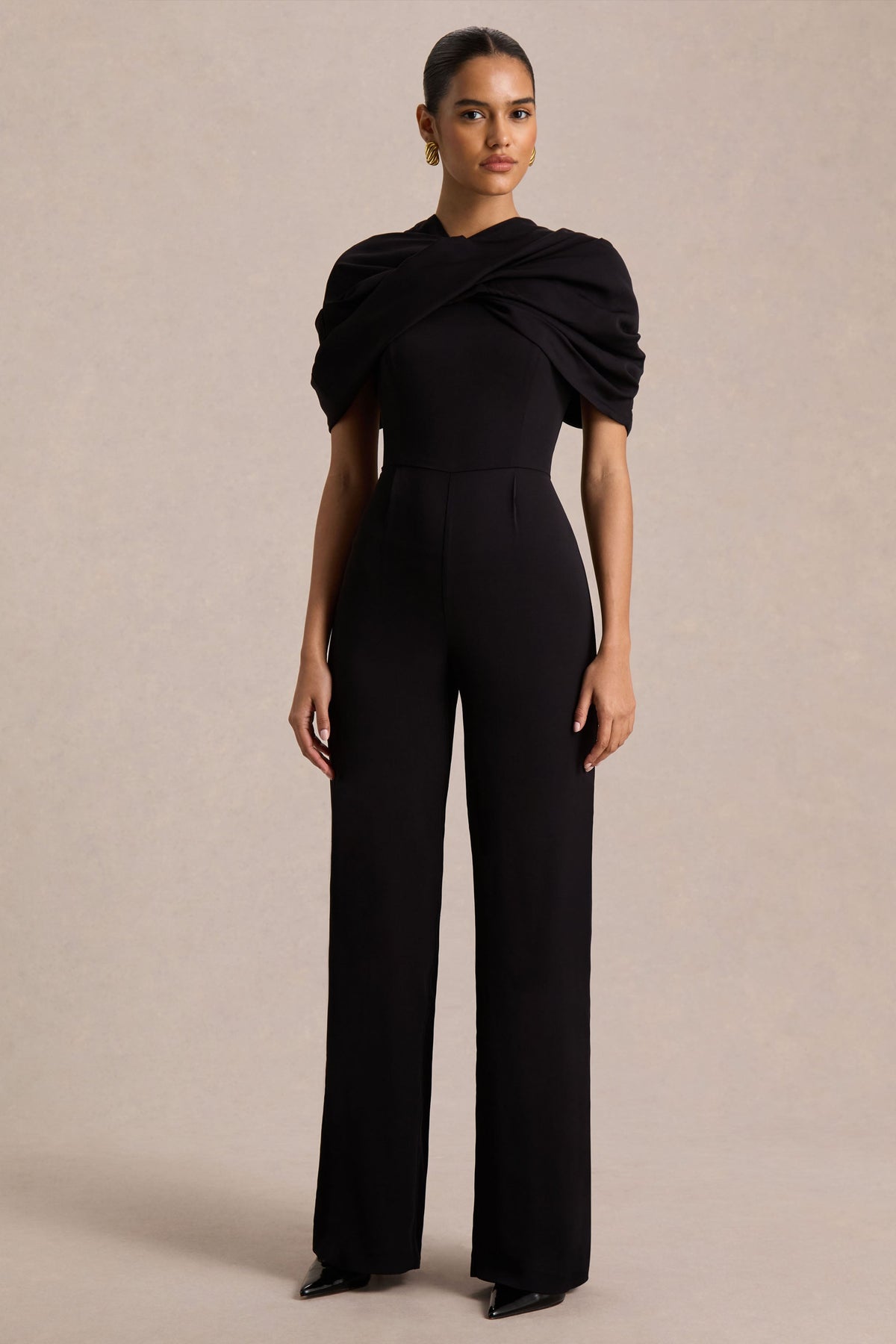 Raquel | Svart byxdress med asymmetrisk halsringning och tvinnad capeärm