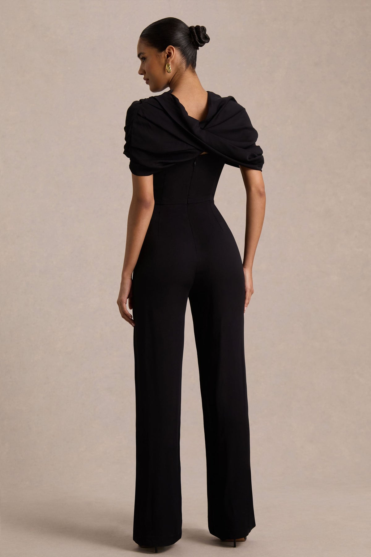 Raquel | Svart byxdress med asymmetrisk halsringning och tvinnad capeärm