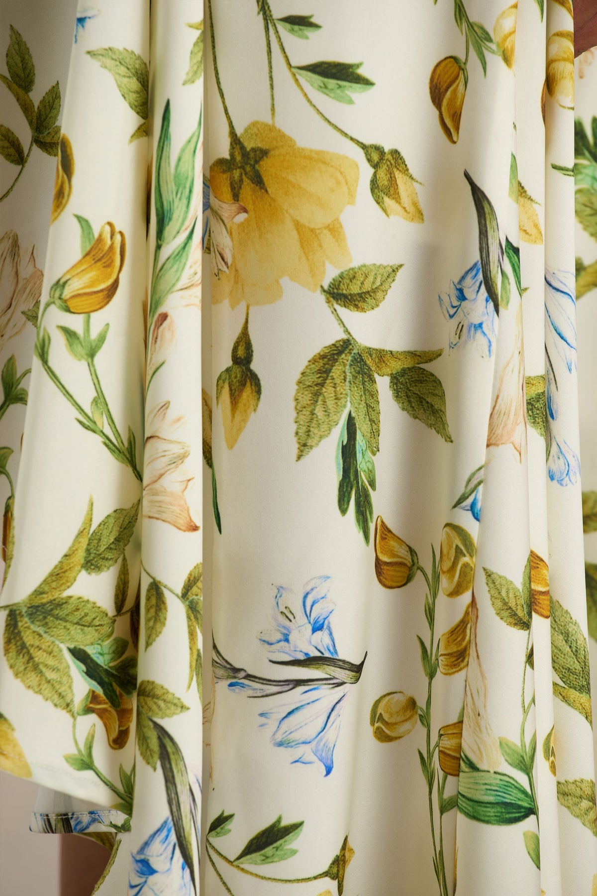 Glint | Vit långklänning med citrongult blommönster och asymmetrisk fåll