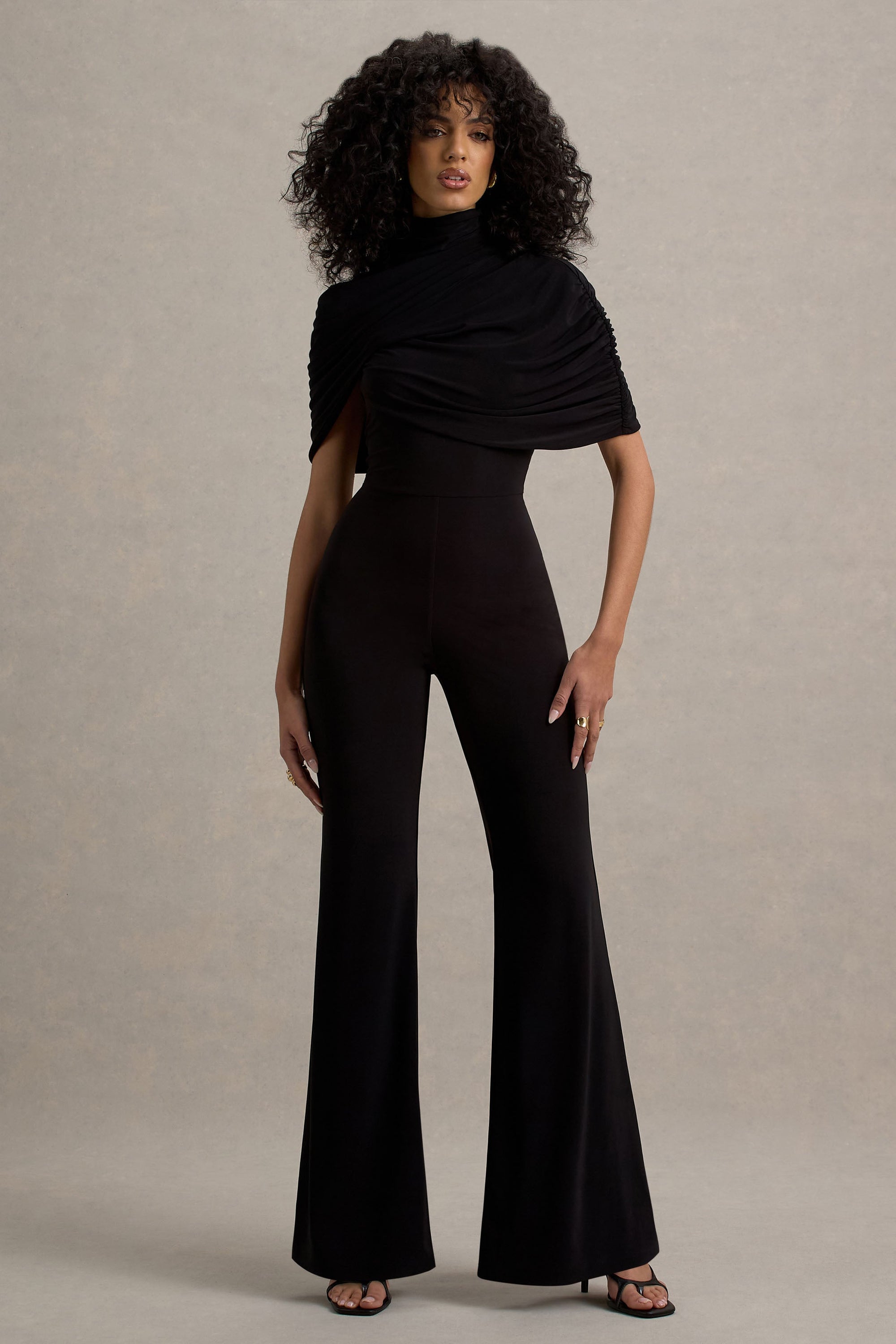Isoline | Svart byxdress med capeöverlägg och klockade ben
